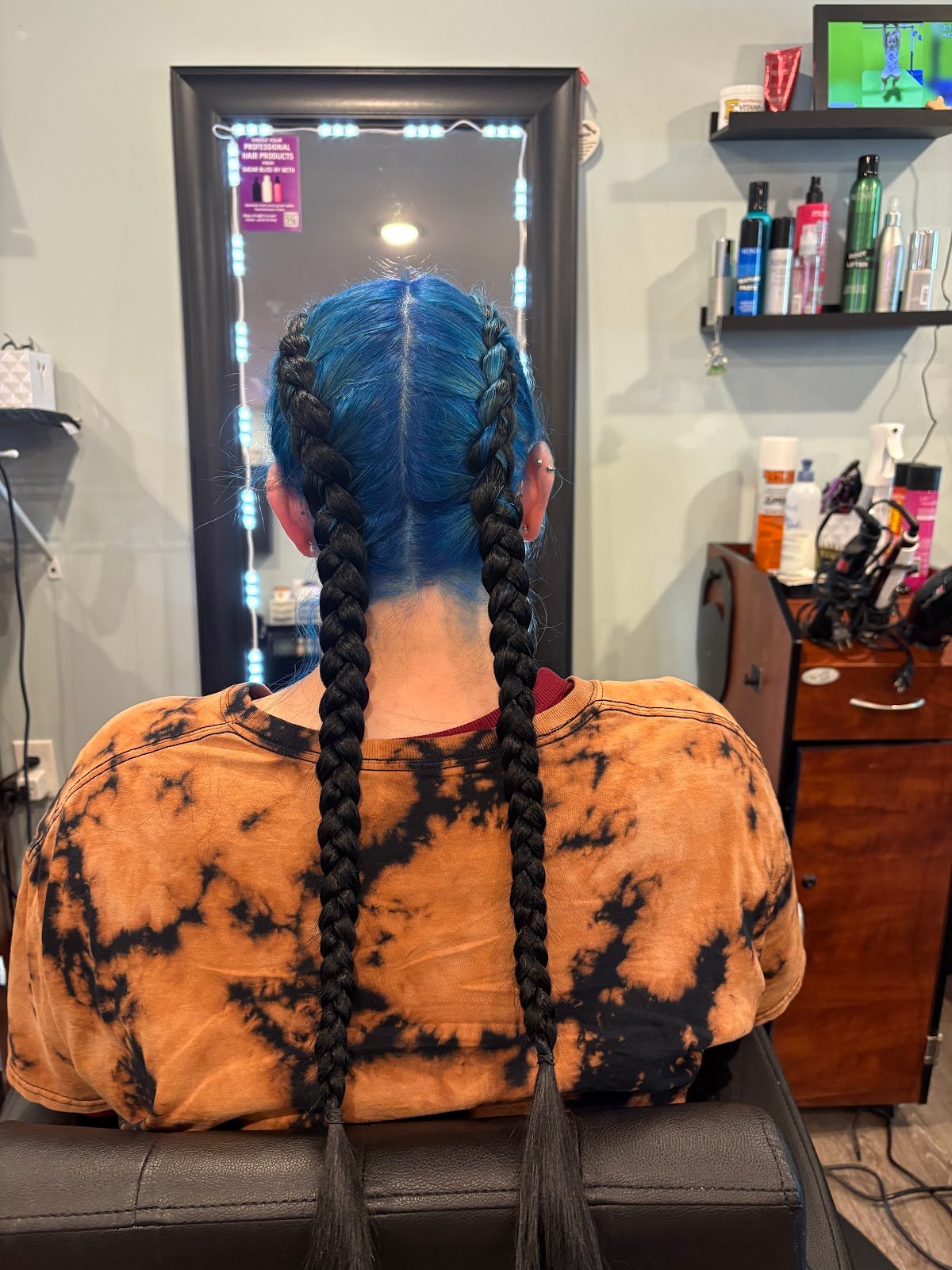 Blue hair styled into two long dark braids, photographed at Simply Shear Sisters